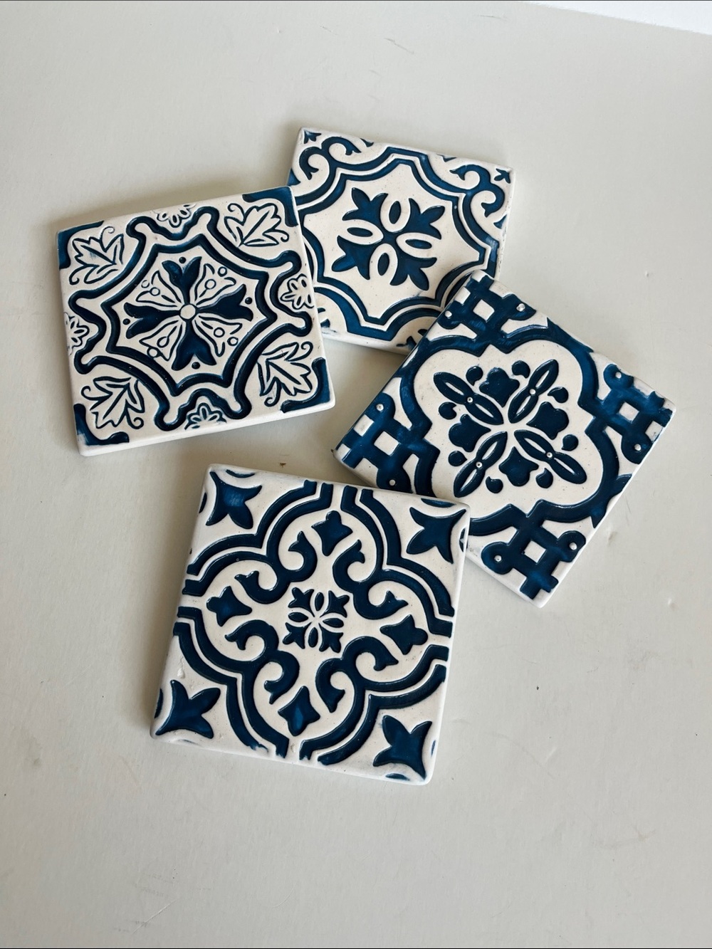 Four Blue and white ceramic tile coasters.